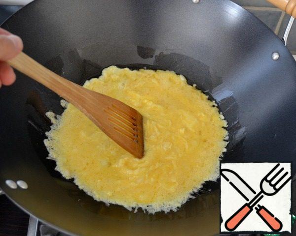 In a frying pan (best in wok, that is, in a special deep frying pan with thin walls, often used in Chinese cuisine for fast roasting of products!) heat 2 tablespoons of peanut butter and pour the eggs and onions. Fry the egg mixture, stirring all the time...