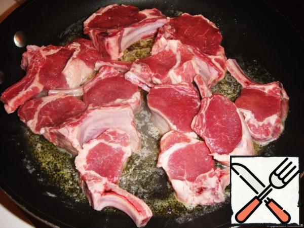 Cut the lamb into rather large pieces and put it in a frying pan with melted butter.
