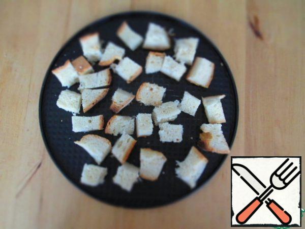 Meanwhile, 2 slices bread cut into cubes and bake under grill under maximum temperature until Golden brown. Put them in a deep bowl, add 1 tooth. garlic passed through the press. Stir.