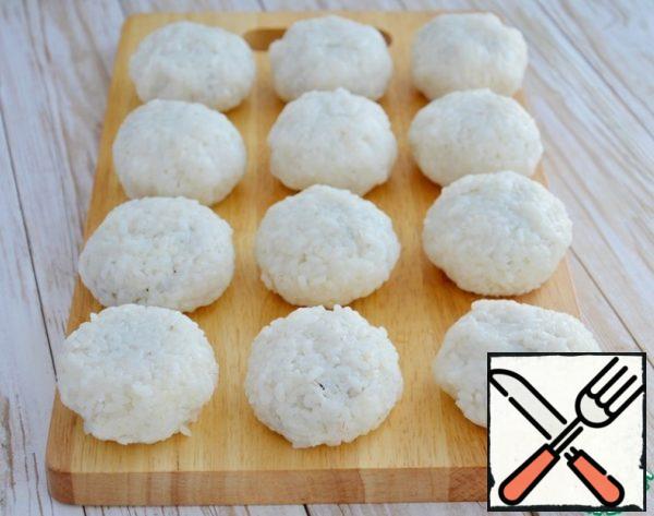 Moisten your hands with water (be sure, otherwise it will be difficult to form cutlets), put rice in the palm of your hand (I have about 70-80 g of rice), make a recess in it, put about 1 tablespoon of filling in the recess, form a round cutlet. That's 12 pieces.
