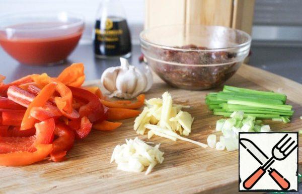 Peppers cut into strips. Ginger is a fine straw. Crush the garlic. Green onions cut into rings.