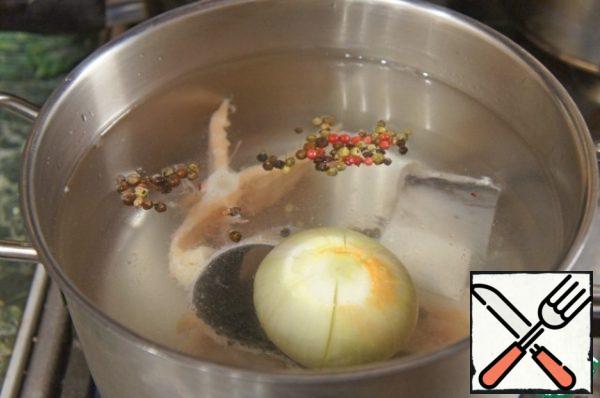Skin, bones and fins put in a pot, pour cold water in the amount of a little more than 2 liters, add the onion cut in several places, a mixture of peppers, bring to a boil, remove foam and cook on low heat for 30-40 minutes.