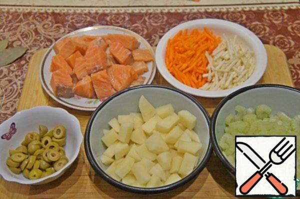 Carrots cut into strips. Celery stalks washed, cleaned of veins and cut into slices thickness of 2-3 mm. Olives cut into rings (3 pieces each), potatoes in small pieces.