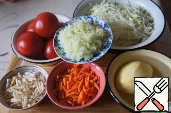 Cut carrots and celery into strips, chop onion and garlic. Finely chop the cabbage.
