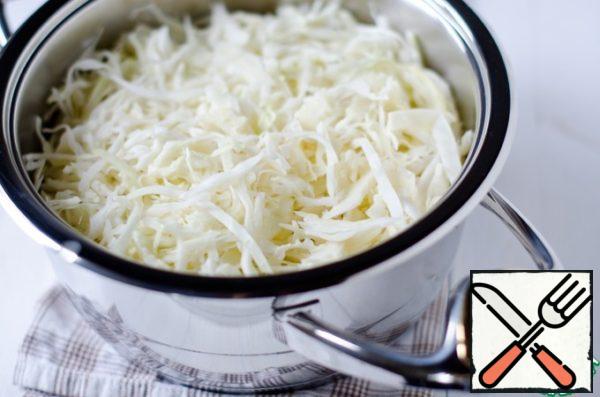 Chop the cabbage and put it on the meat. I note that at this stage we do not add water, vegetables and meat will boil due to their own moisture.
