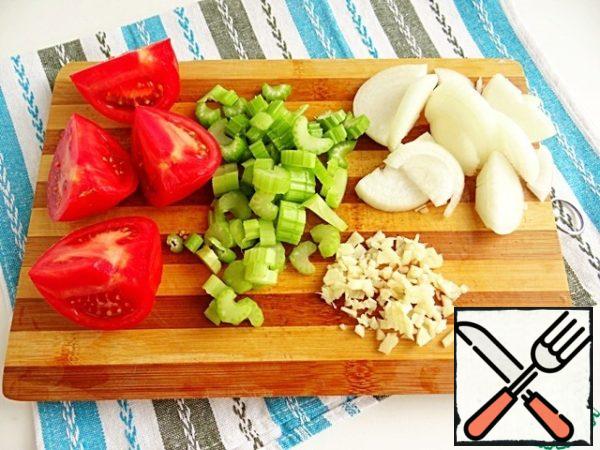 Wash the vegetables and cut the tomato into 4 parts, onion in half rings, coarsely, celery in small pieces, garlic chop with a knife.
