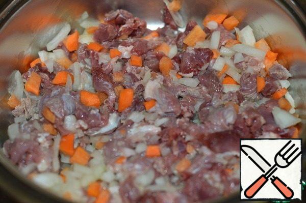 Put the meat, onions and carrots in a saucepan, fry, stirring, for a couple of minutes.
