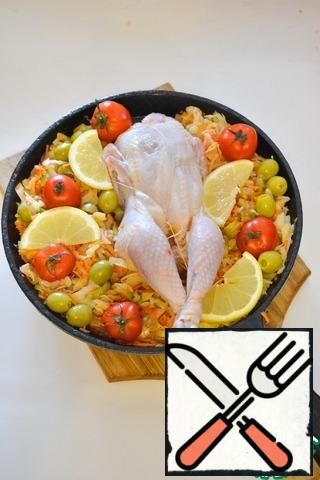 In the baking dish put the remaining cabbage, place in the center of the stuffed chicken, lubricate it with vegetable oil. On top of the cabbage and put whole small tomatoes, remaining olives and lemon slices.Pour about 100 ml of water. If the cabbage is juicy, the water may not be necessary at all.
In such a the form of put all in the oven, heated until 180 degrees. Bake until chicken is cooked (about 40 minutes).
