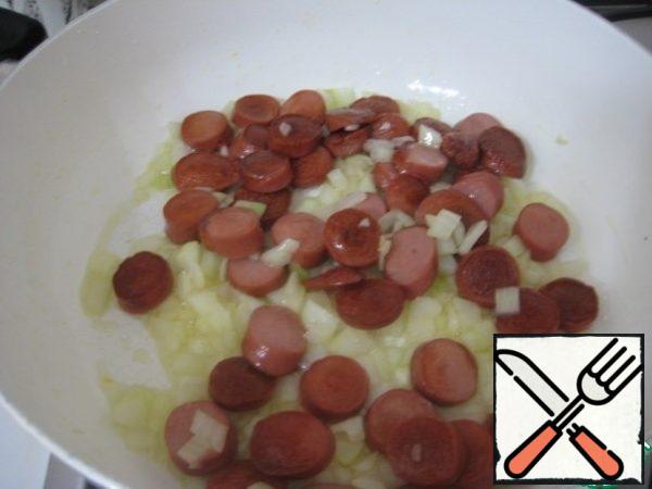 Cut sausages in circles. In a deep frying pan, heat olive oil, fry the sausages until Golden brown. Onions finely chop, add to sausage, cook 5 minutes, stirring constantly.