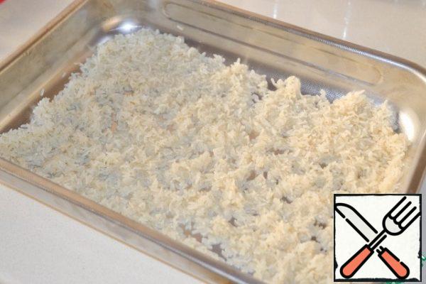 In a deep baking sheet spread an even layer of washed rice. 