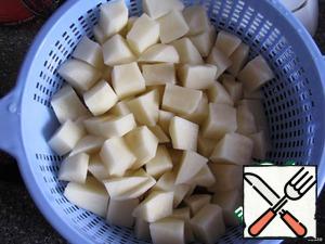 Potatoes cut into medium-sized cubes and lay in a pot of boiling water.