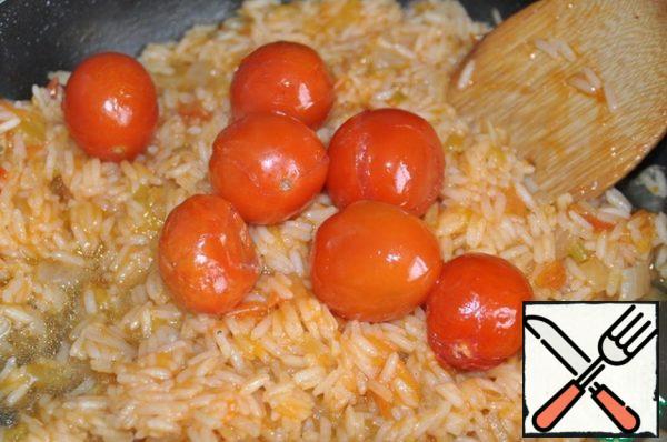 Once the chicken is ready, put the baked cherry tomatoes (from chicken) to the rice.
There also pour the juice left over from baking the chicken.