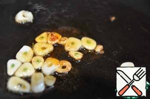 On the remaining oil fry until smell 2 cloves of garlic, sliced into plates.
Turn off the fire and add half a teaspoon of sweet paprika, stir.