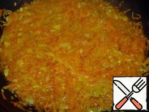 Onions and carrots fry in vegetable oil.