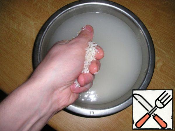 So, it all starts with washing rice. Wash it only with cold water, rubbing between your fingers and palm. In the photo, I took my hand out of the Cup to show how it's done, but in fact, the hand should be in the Cup or under a stream of water.