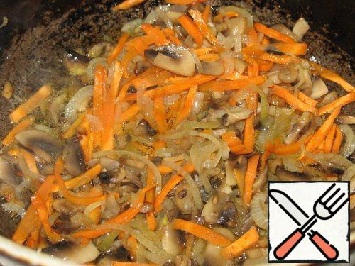 Mushrooms, onions, carrots fry in vegetable oil.