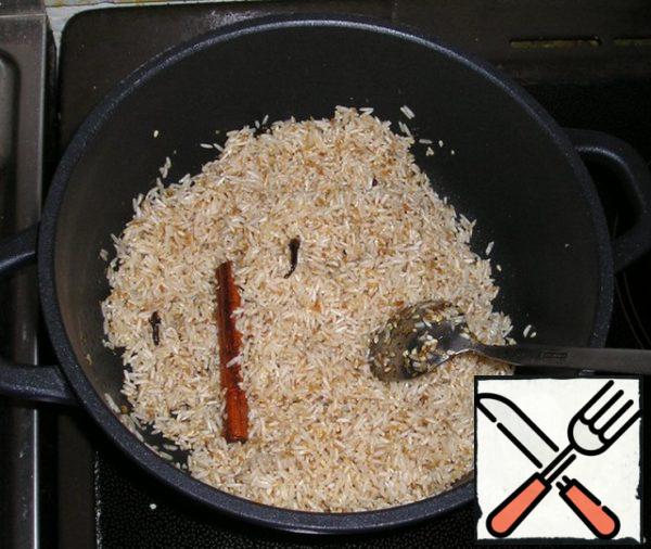 Now pour the rice and fry it for a few minutes until the rice grains become slightly transparent.