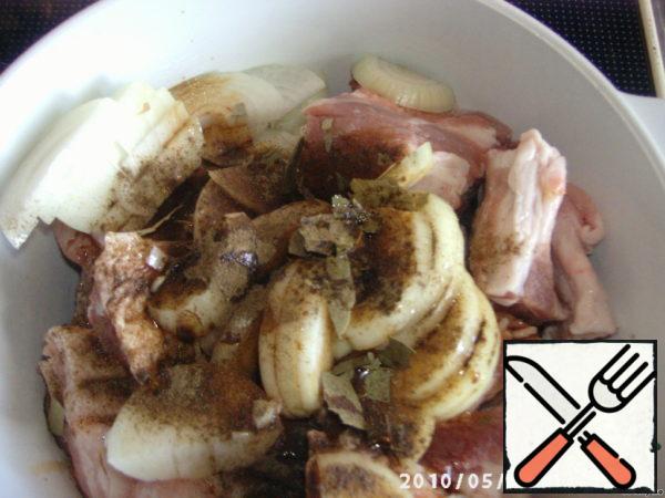 Onions are cut into half rings, soy sauce is mixed with cognac and the ribs are poured. Salt and pepper, add spices and send them to the refrigerator for a couple of hours.
