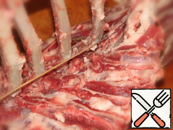 Then carefully, somewhere with your fingers, and somewhere with a sharp knife, separate the meat from the ribs to the spine. You should try not to tear the meat.
Then cut a little where the vertebrae join, but in such a way as to preserve the integrity of the piece.