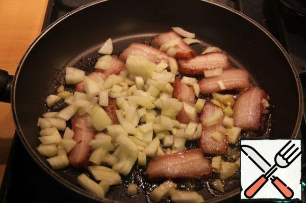 Without removing the lard from the pan, add the finely chopped onion.
