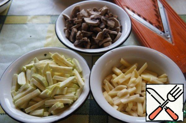 In the meantime, prepare the rest of the products. Cut potatoes and zucchini into cubes, mushrooms into slices, chop garlic.
