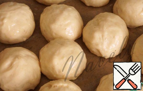 Meanwhile, the dough has come up, cut it into small balls, the size of a walnut, let them come up for 20 minutes, brush with egg on top and put in a preheated oven to 200 degrees for 15-20 minutes.
