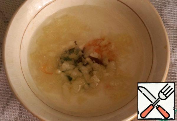 Prepare garlic filling for donuts. Grate a clove of garlic on a fine grater, add salt on the tip of a knife, 1 teaspoon of water, mix well.