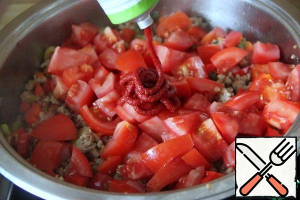 In the pan, after the broth, add tomatoes, cut into small pieces, tomato paste.