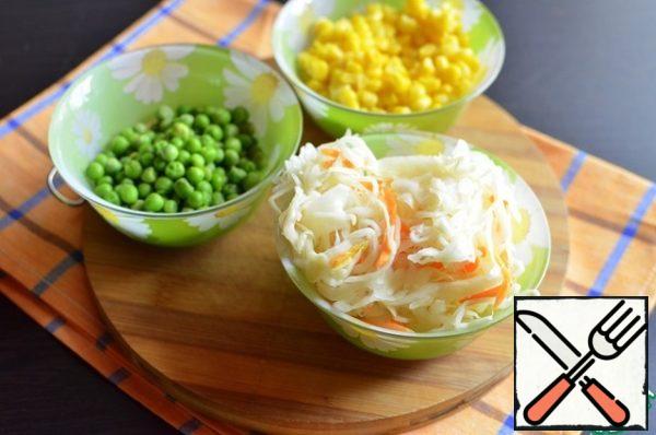 Freshly frozen peas boil for 2-3 minutes from the moment of boiling. Pickled cabbage squeeze from excess juice, slightly cut with scissors. Drain liquid from canned corn.