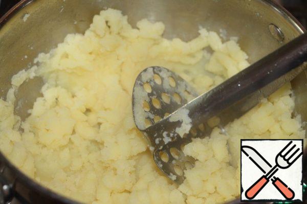 Drain the water, dry the potatoes, mash potatoes, but not until smooth puree.