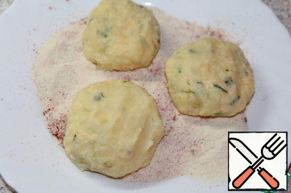 Form of potato mass balls, roll them in a mixture of semolina and paprika.