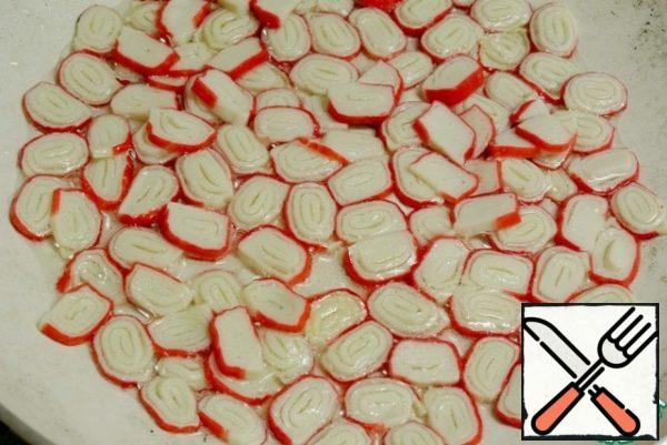 Defrost crab sticks, cut into slices and fry in the same oil in which the mushrooms were fried. In the process of frying, the circles of crab sticks turn into spiral rings.
