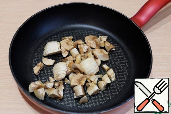 Mushrooms put in the pan, add vegetable oil. Mushrooms lightly fry.