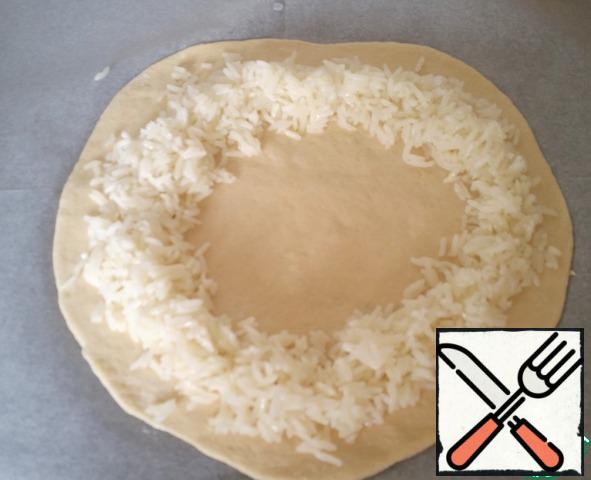 Yeast dissolve in warm water, add sugar, salt, oil. Sift the flour and (gradually adding) knead the dough, it should be smooth. Put the dough in a container and cover with cling film, pressing it to the dough. Leave on for 30-40 minutes. The finished dough divided into pieces, formed into balls and roll out flat cakes in the thickness 1,5 - 2 see Cakes lay on a greased baking sheet and leave to rise... after put the cooked rice.