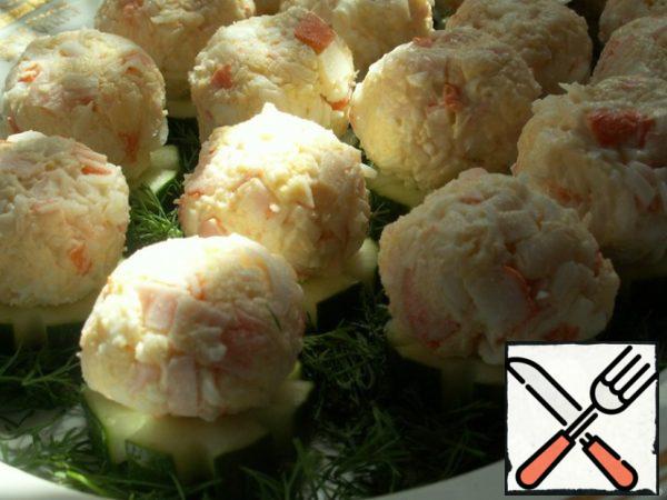 Finely chop crab sticks, grate cheese on a fine grater, eggs on a coarse grater. Add salt to taste and add mayonnaise (add gradually, the salad should not be non-ionized).
With wet hands, roll the balls out of the salad mass and put them on the cucumbers.