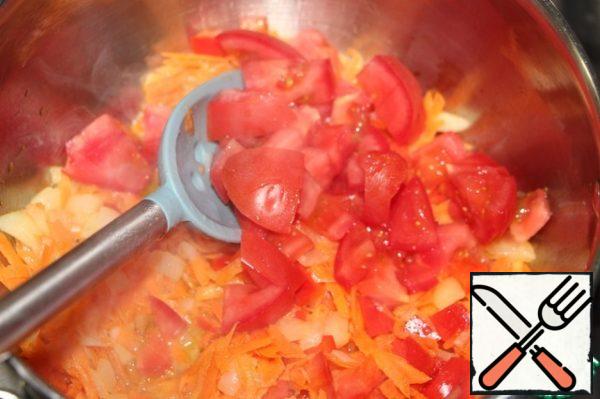 And a tomato, also diced. Stir the vegetables. Simmer for 2-3 minutes.
