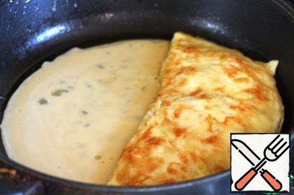 Pour in the vacated space remains omletes mixture, wait until the edges will grab and flip her omelet with filling.