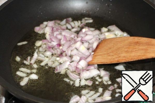 In a deep frying pan, heat the vegetable oil, fry the onion and garlic for 2-3 minutes, stirring.