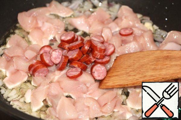 Add the chicken breast cubes, slices of sausage, mix.
