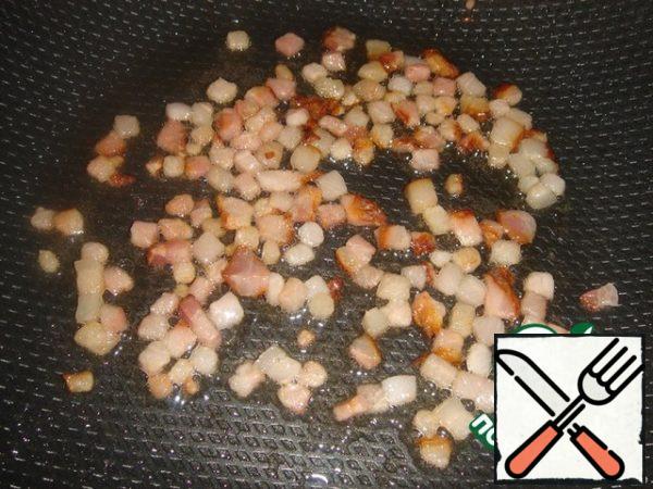 Rice is prepared, now proceed directly to the preparation of the dish.
To do this, cut the bacon into small cubes and fry in a pan until brownish. Remove the fried bacon from the pan.
