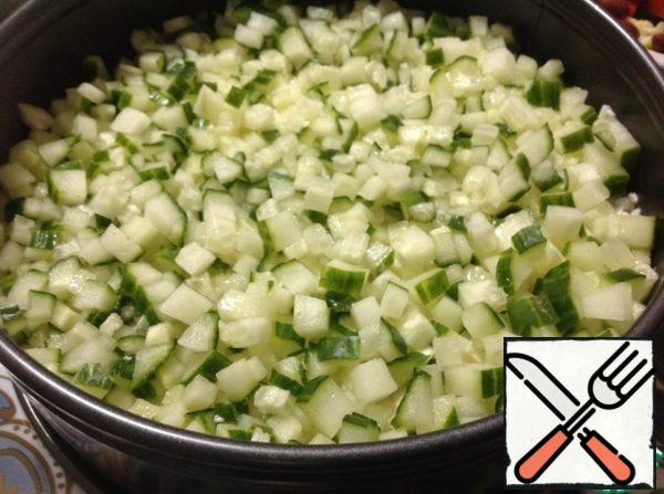 The next layer is cucumber, cut into small cubes.
