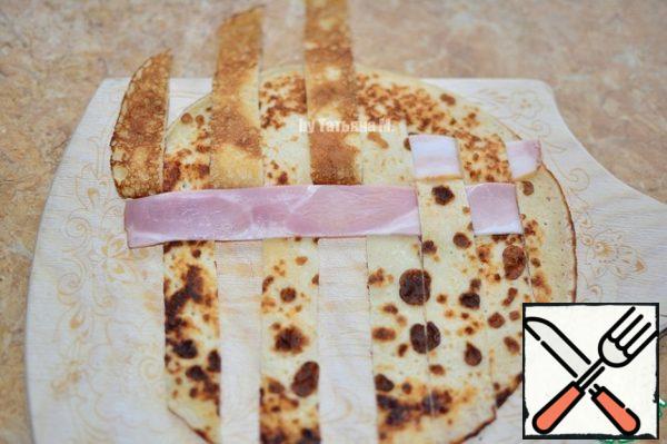 Pancake put on the surface, cut into the same strips as bacon, without cutting the pancake on one side.
Put the damn bacon strips in checkerboard pattern.