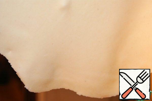Roll out each piece into a circle 1-2 mm thick. Do not sprinkle the countertop, so it will be easier to roll out a thin dough.
