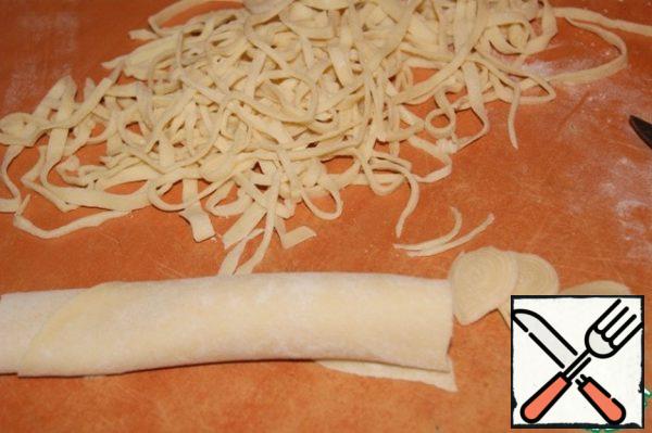 Roll the dough into a roll and thinly cut into washers.
You can adjust the length and width of the noodles by yourself.