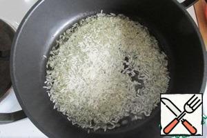 Pour oil into a saucepan, heat it and put dry rice.
When mixed with oil rice becomes translucent.
Fry the rice, stirring to white, min 7 - 10.