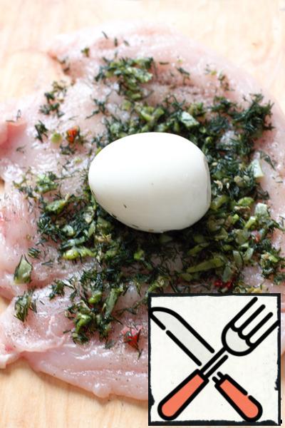 Beaten pieces of salt, pepper, spread the chopped greens and place the boiled egg in the center.