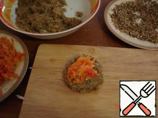 Fry the finely chopped carrots with onions (cut into rings), and tomato (cut into cubes).
Add spices.
Prepare ground walnuts. From 1 tbsp eggplants to make the cake, put the fried (cooled) vegetables, they are again to put the cake of eggplant.
Connect the edges.