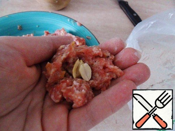 How to knead the minced meat.
Hands lubricate with vegetable oil and take a little minced, in the center press 2-3 nuts and roll the ball with a diameter of 3-4 cm. 