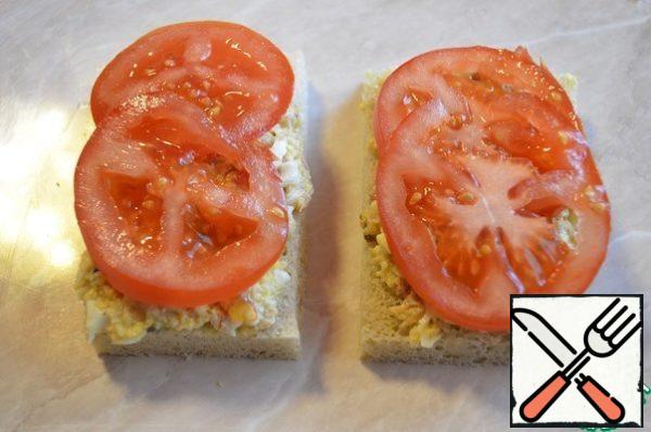 Cut the bread, spread the resulting mass, put the tomato and close the sandwich with another piece of bread. The sandwich turns out to be soft with a delicate filling.
