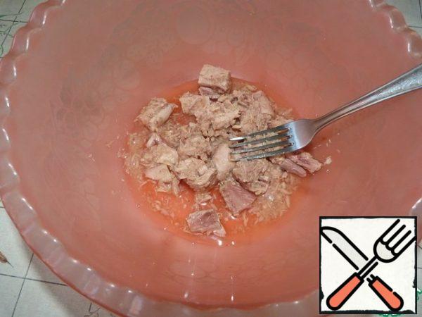 Then put a can of tuna in a bowl and mash with a fork.